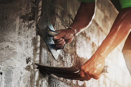 装修石匠工人们在建筑房屋墙上涂水泥的紧手行业图片