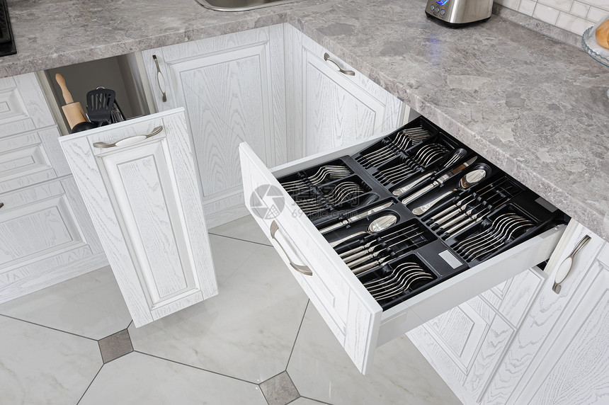平铺现代白色厨房中带银餐具的黑开放式抽屉现代白色厨房中带银餐具的抽屉黑星光图片