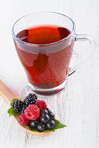 勺子水果红茶和野用木勺在白桌上夏天饮料图片