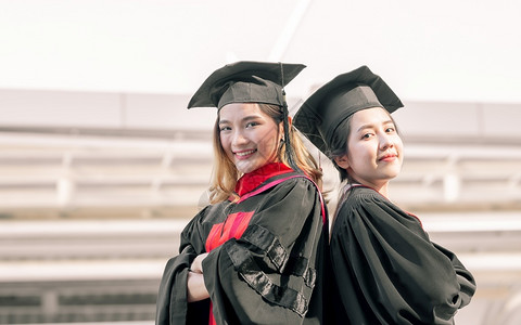 两位身穿红色学士服拍照的女学生图片