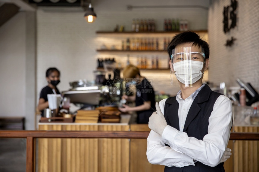 服务咖啡和餐馆店主表示他们有信心佩戴面罩和手套概念保护coviD19防止COVID19或冠状常设店铺图片