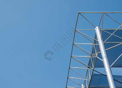 屋檩正面现代金属框架在明蓝天空下展楼的树冠画布上使用现代金属框架图片
