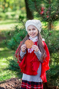 空气微笑漂亮的女孩手里拿着饼干在假期前院子里露天闲暇图片