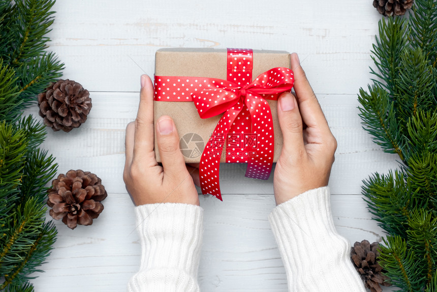 桌子雪持有礼品盒圣诞装饰和木背景的松树枝节日概念准备新年快乐和Xmas假日顶端风景等礼物盒的妇女装饰风格图片
