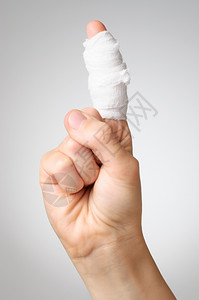 疮伤痛的手指和白纱布绷带援助病人背景图片