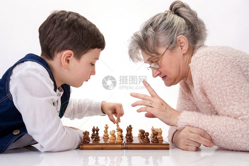 奶和侄子面对地打象棋聪明的在室内家图片