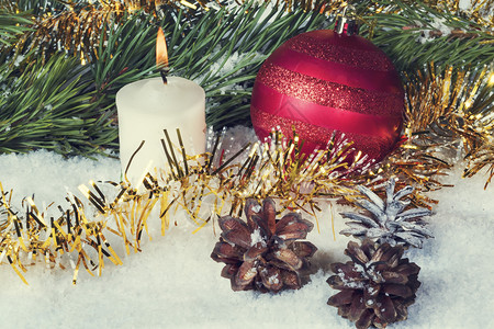 乡村新年球蜡烛和螺旋锥在锡盘和树枝之间用装饰品和蜡烛的贺卡之中冷杉图片