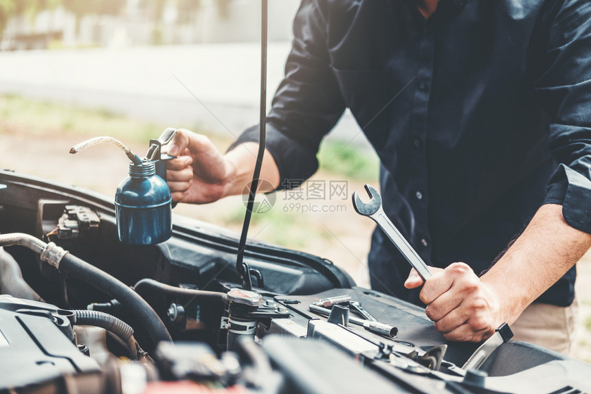 电的机械在车库工作的汽修理技术员在汽车修理服务和维汽车检查中工作的汽车修理手电池图片