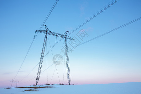 建造黄昏柔和的日落时空旷冬田中电力线支柱图片
