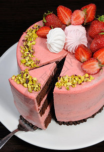 甜点营养的开心果一个巧克力切片草莓慕斯蛋糕配有浆果梅林瓜和菠萝图片