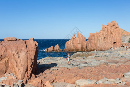 巨石礁海浪意大利Arbatax海附近的Sardinia海岸线典型红岩和克里夫斯以及旅游者背景图片