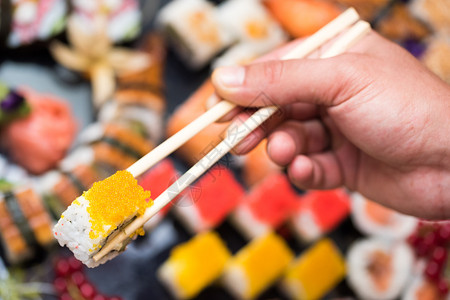 木头传统的保持人肉手握着寿司用筷子顶视线图片