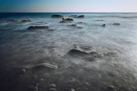 轮廓天空科孚岛在爱托尼海岸线冲浪时长期于岩石的图片