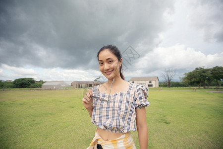 常站着的女子在公园欢乐地抱着和微笑请享用裙子美丽图片