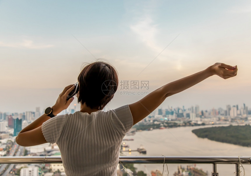 早晨站在阳台与城市对BangkokCopy空间选择焦点的视线相对立年轻女子背面士放松图片