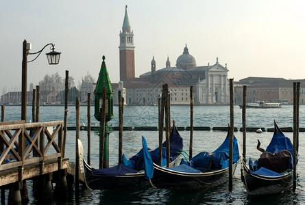 威尼斯人建筑学桑Gondolas在意大利威尼斯运河上停泊图片