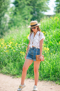 时尚夏日露天公园户外的年轻女子在公园户外戴帽子的年轻女玫瑰漂亮的图片
