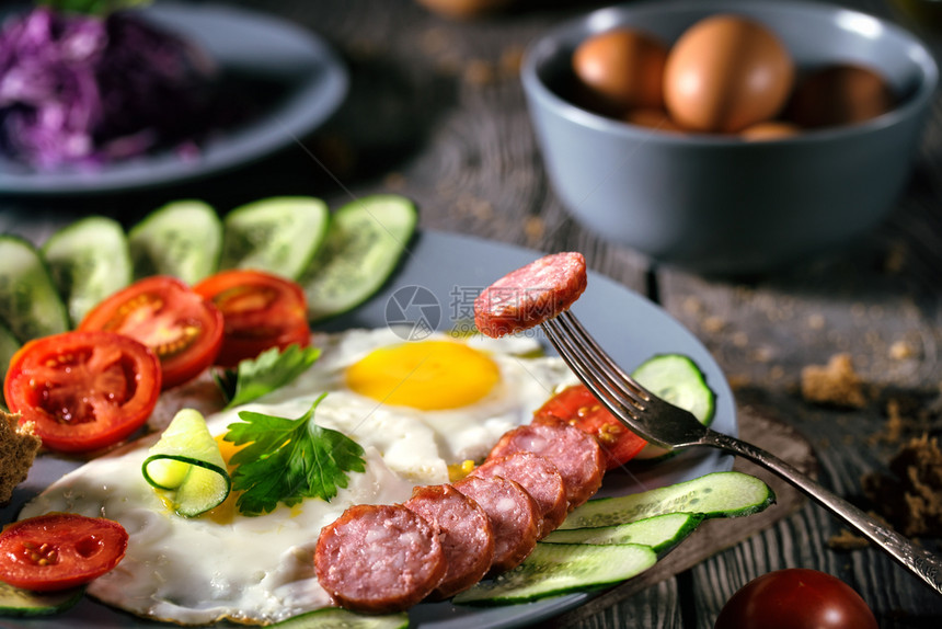 白色的盘子蔬菜和香肠在木制桌上的炒鸡蛋健康食品概念生菜式早餐烤鸡蛋在木制桌子上加蔬菜和香肠图片