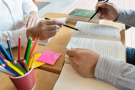 学生在书桌上帮朋友讲解功课图片