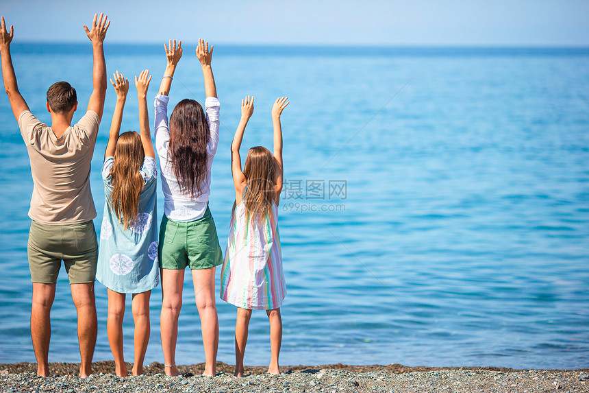 四口家庭在海滩度假时一起玩得开心年轻度假家庭玩得很开心爸跑步为人父母图片