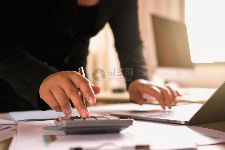 在职的图表利用膝上型电脑核对办公室财务数据的办公桌上女商业人战略图片