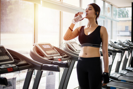 毛巾室内的在健身锻炼后运动妇女作为的饮用水健康概念喝图片