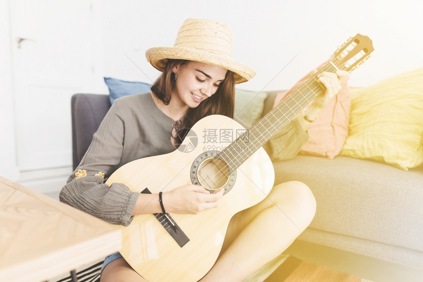 肖像身戴帽子并弹吉他回家的少女孩笑着微时尚声音图片