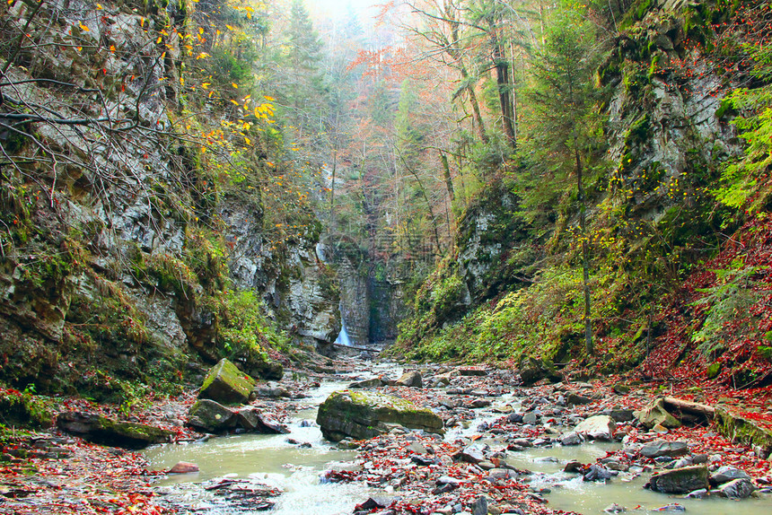 流动瀑布与水从喀尔巴阡山脉的马尼亚夫斯基瀑布的悬崖上落下水从悬崖上落下山中的秋季景观与河流山区的秋季景观与河流山区喷射图片