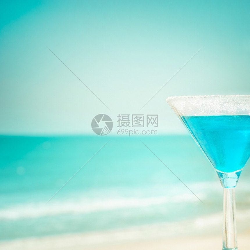 沙滩上的蓝色玛格丽塔鸡尾酒图片