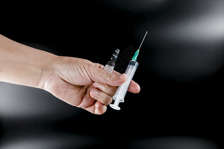 手拿疫苗注射器特写图片