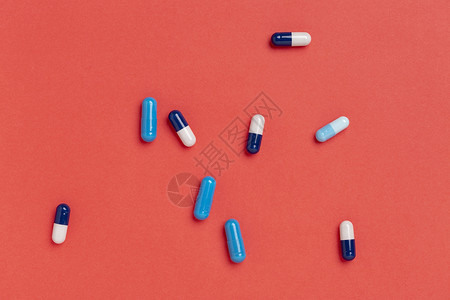 蓝药胶囊红色背景的蓝药物胶囊彩品单一颜色背景制药紧急情况反抗图片