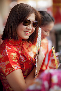 化妆品身穿传统西装带着牙尖笑脸的竹风扇亚洲女人在千金镇们保持图片