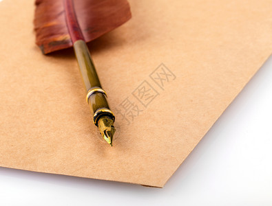 笔记商业古老的烧旧信封上面有白色背景的短羽毛笔黄色图片