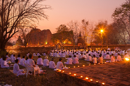 节日卡3月4日MakhaBuchaDayTaltitional佛教僧侣正在泰国Ayutthaya的Maheyong寺庙为宗教仪式点蜡烛背景