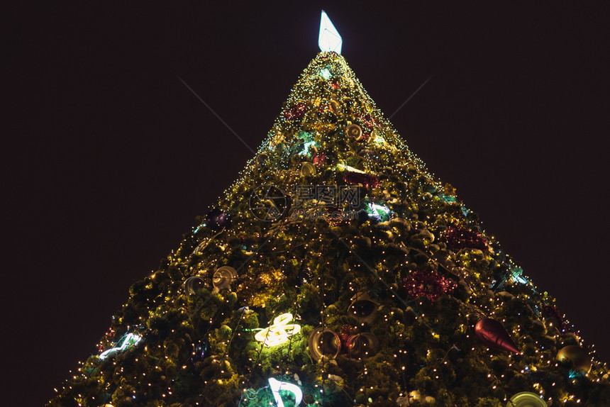 闪发光新年树用古典玩具装饰用灯光照亮黄色的充满活力图片