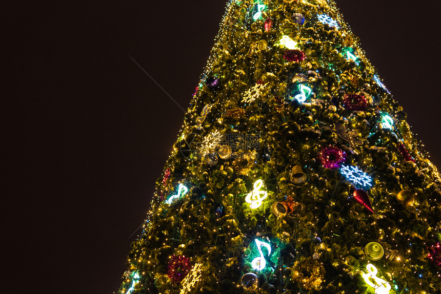 明亮的美丽模糊新年树用古典玩具装饰用灯光照亮图片