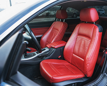 豪华轿车内装有红皮座椅和黑色细节驾驶车轮新的图片