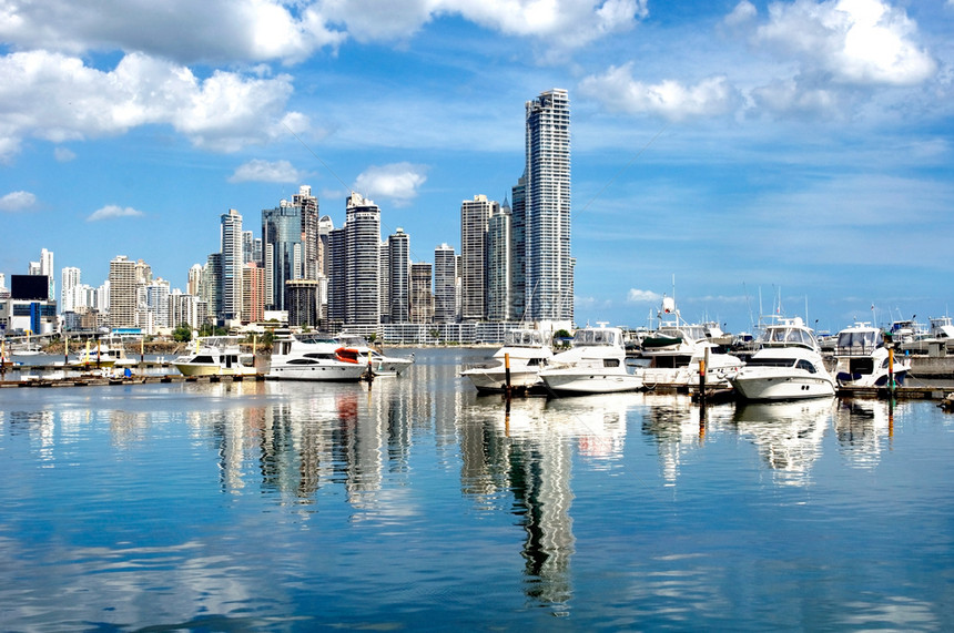 运动的海岸田园诗般位于巴拿马城豪华游艇其背景是带有水反射的摩天大楼巴拿马城图片