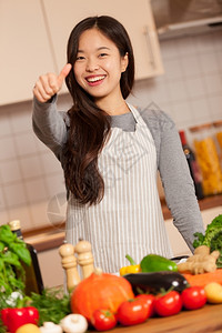 亚洲女人在厨房做正面的拇指手势成功女士屋图片