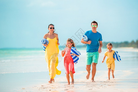 喜悦年轻的家庭一起在海滩度假年轻的家庭在海滩度假马尔代夫水图片
