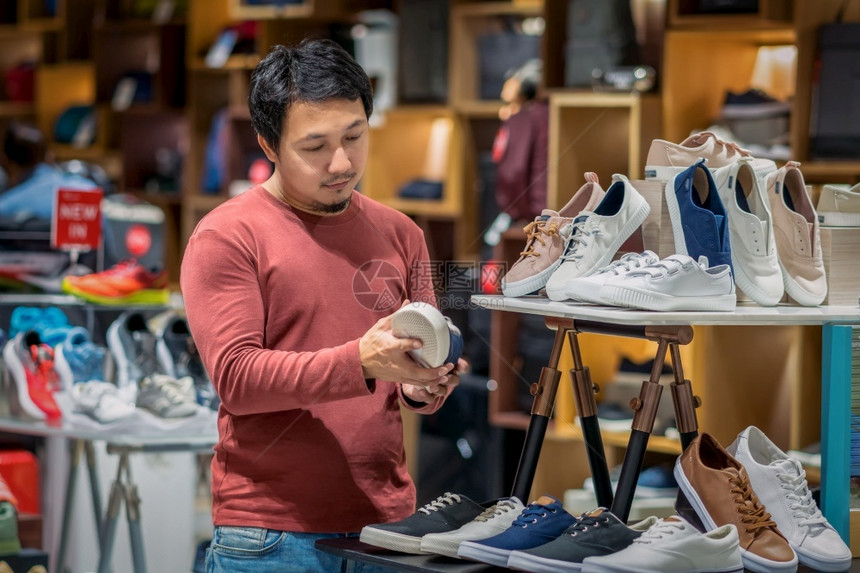 在百科购物中心商店铺选时装鞋美容和消费主义概念的留胡子聪明亚洲男年轻的时尚愉快图片