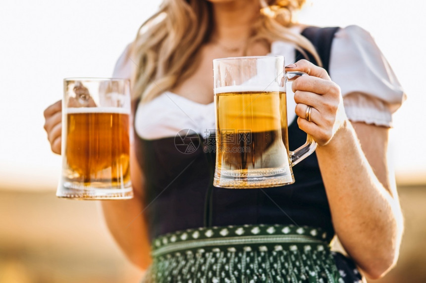 巴伐利亚女绿色传统节日礼服Dirndl的金发女郎近身照片在圣帕特里克斯StPatrickrrsquoos国际啤酒日概念Oktob图片