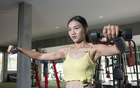 积极的亚洲运动女在健身房用哑铃黑发保持青少年高清图片素材