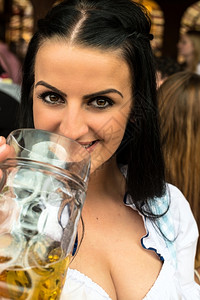 玻璃闲暇庆祝穿着传统Dirndl礼服的女孩俄罗斯人接触国但也可能是希腊人正在喝啤酒和Oktoberfest玩乐美丽的高清图片素材