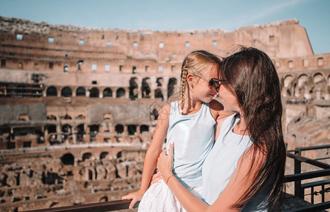 圆形小女孩边框人们父母圆形剧场在罗马快乐的家庭背景肖像在欧洲著名的地方欧洲年轻母亲和小女孩抱在意大利罗马的ColiseumCariseum背景