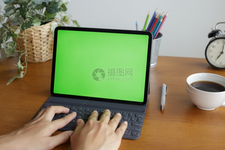 商业亚裔女手在使用平板电脑时在窗边的桌子上有一个绿色屏幕拥有一种图片