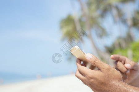 细胞一个人在海滩上用手机的人触碰移动图片