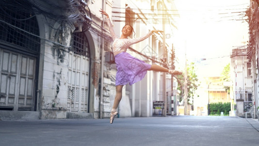淡紫专业的淑女在泰国曼谷街上跳舞的年轻美丽芭蕾舞女郎演员背景