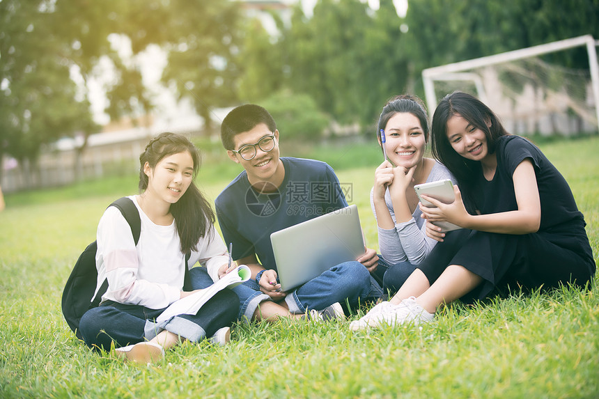 亚洲学生们在草坪上一起分享想法图片