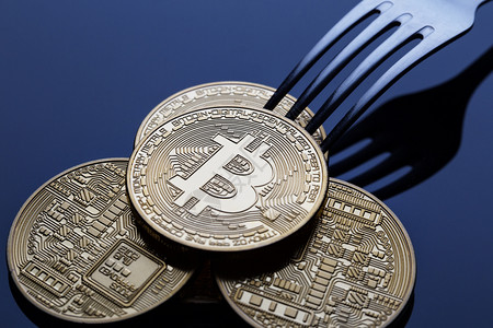 bitcoin互联网比特币插件Bitcoin在蓝色背景上加金比特币的叉子概念分隔虚拟货币比特插件区块链概念的设计图片
